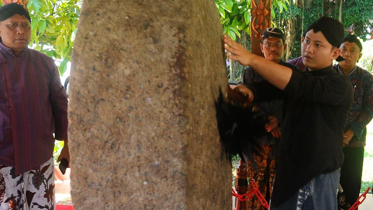 Bupati Trenggalek, Mochamad Nur Arifin membersihkan Prasasti Kamulan selama melakukan tradisi jamasan tujuh pusaka di Pendopo Kabupaten Trenggalek, Jawa Timur, Rabu (30/8/2023).