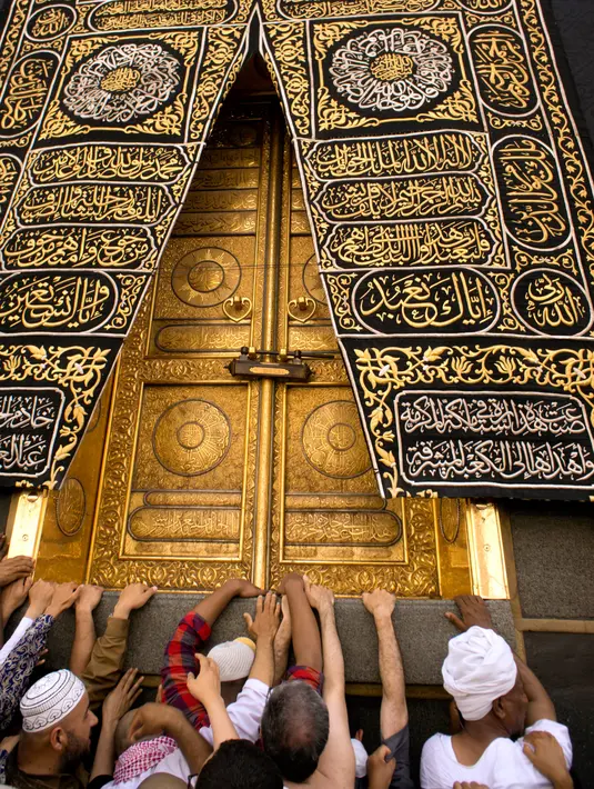 Umat muslim memanjatkan doa dengan menyentuh dinding Kabah selama menjalani ibadah umrah di Masjidil Haram, Mekkah, 4 Mei 2018. Banyak umat muslim yang menyambut bulan Ramadan dengan menjalankan ibadah umrah ke tanah suci. (AP Photo/Amr Nabil)
