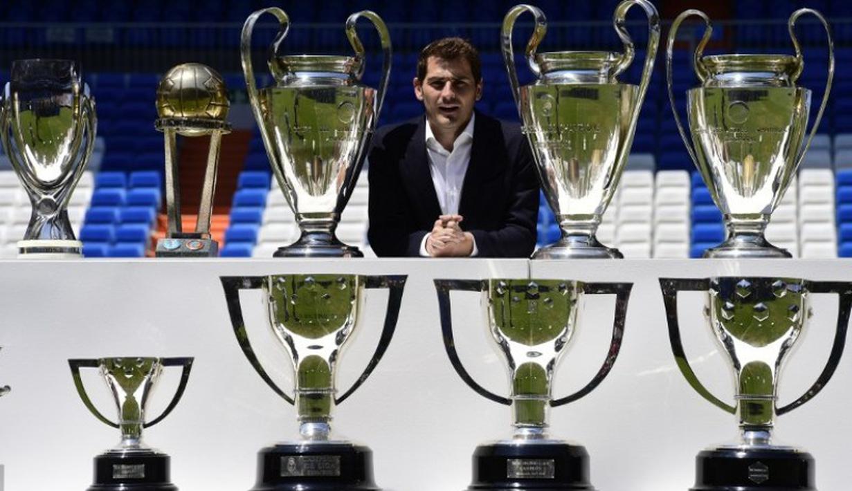 Iker Casillas berpose dengan trofi juara yang pernah diraihnya bersama Real Madrid saat setelah menyampaikan salam perpisahan di Stadion Santiago Bernabeu, Madrid. (13/7/2015). (AFP/Javier Soriano)