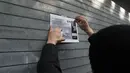 Pemilik toko memasang kertas pemberitahuan di pintu toko kelontong yang tutup di Brooklyn borough New York City, Kamis (2/1). Aksi pemogokan ini merupakan protes terhadap kebijakan imigrasi Donald Trump. (Spencer Paltt/GETTY IMAGES NORTH AMERICA/AFP)