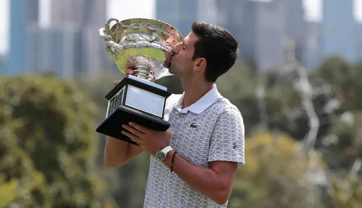 Petenis Serbia, Novak Djokovic mencium piala juara tunggal putra Australia Terbuka 2020 saat sesi pemotretan di Royal Botanic Gardens Victoria, Melbourne, Australia, Senin (3/2/2020). Bagi Novak Djokovic, ini merupakan gelar Australia Terbuka kedelapan. (AP Photo/Dita Alangkara)