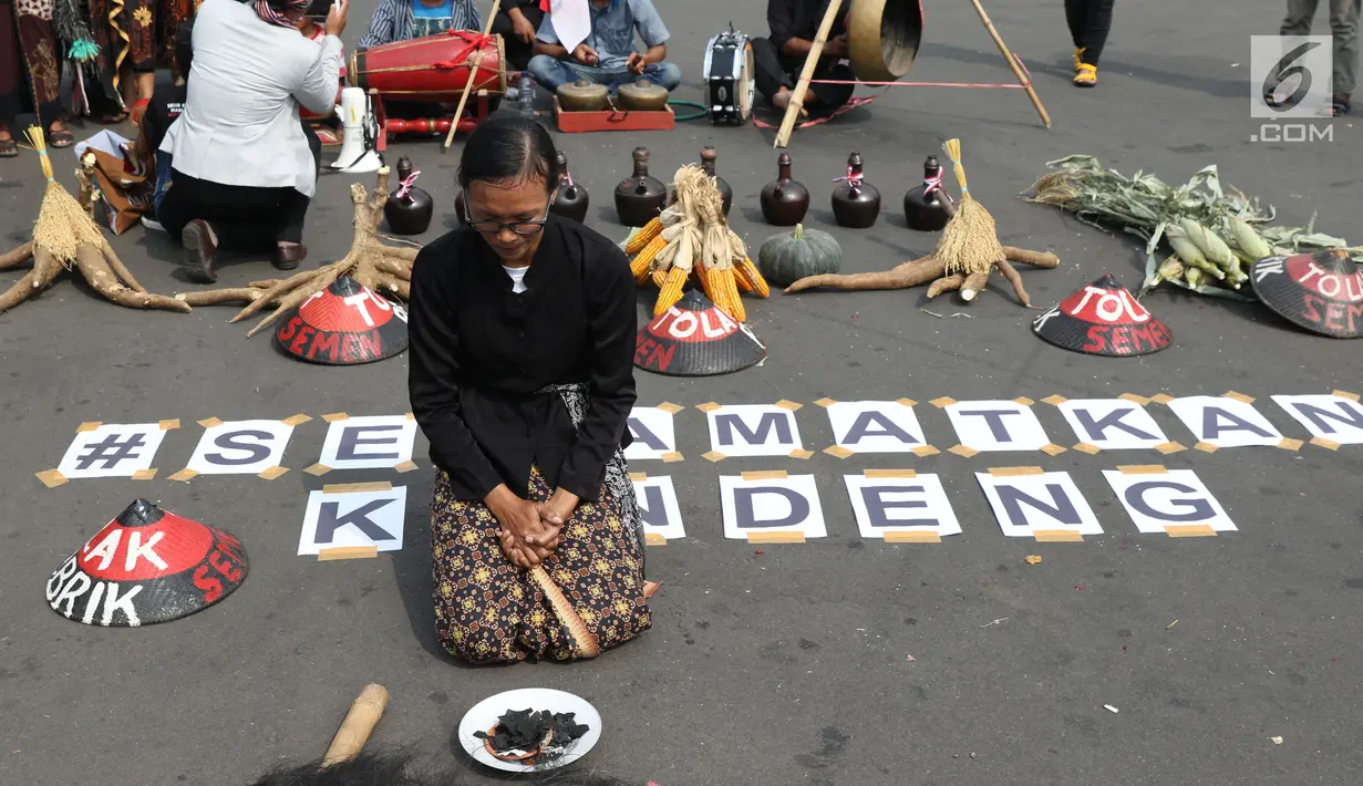 Salah satu petani Kendeng terduduk saat aksi di depan Istana Negara, Jakarta, Kamis (2/8). Dalam aksinya, petani Kendeng melakukan tradisi Brokohan atau makan bersama nasi aneka urap yang sebelumnya didoakan. (Liputan6.com/Helmi Fithriansyah)