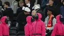 Orang-orang berpakaian seperti penjaga Squid Games dengan berdiri di area penonton selama pertandingan lanjutan Liga Inggris 2024/2025 antara Tottenham Hotspur melawan Liverpool di Stadion Tottenham Hotspur, London, Inggris Minggu (22/12/2024). Seperti diketahui, aksi tersebut ternyata merupakan promo musim kedua serial Korea Selatan tersebut. (AP Photo/Dave Shopland)