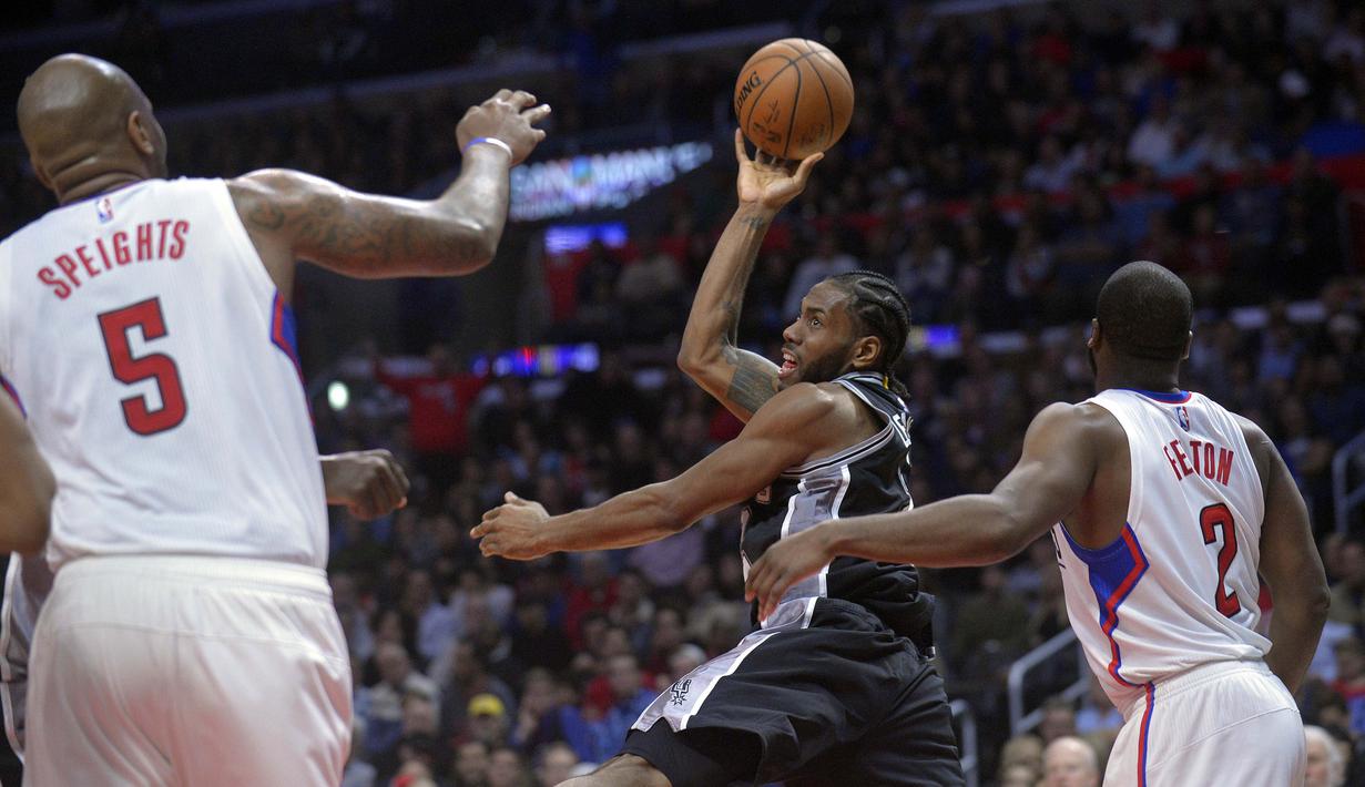 Pemain San Antonio Spurs, Kawhi Leonard (tengah) melakukan tembakan melewati hadangan para pemain L. A. Clippers  pada laga NBA basketball game di Staples Center, (22/12/2016). Clippers menang 106-101. (Reuters/Gary A. Vasquez-USA TODAY Sports)