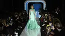 Model AS, Gigi Hadid berjalan membawakan koleksi terbaru Moschino di panggung runway Milan Fashion Week 2018, Rabu (21/2). Gigi terlihat cantik dengan gaun warna hijau muda beraksen sparkling di bagian lengan dan leher serta kakinya. (Miguel MEDINA/AFP)