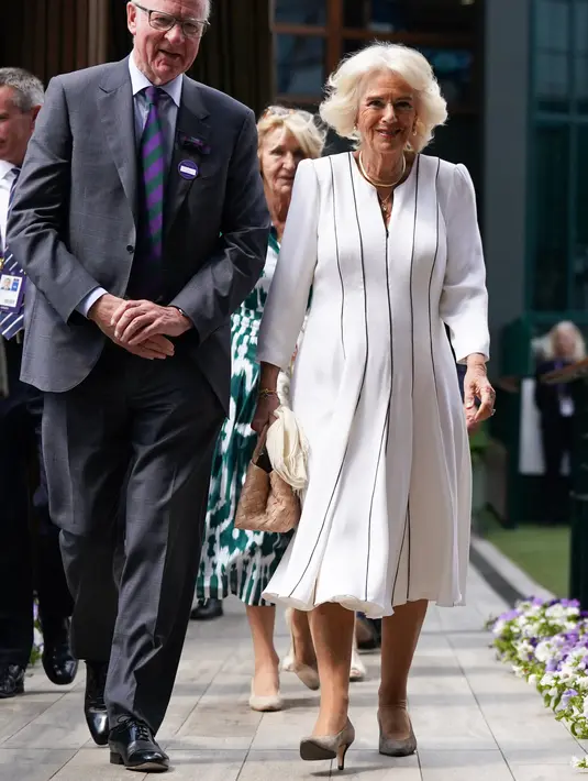 Di bagian alas kaki, sang figur publik melangkah dengan sepasang sepatu hak tinggi berbahan suede berwarna abu-abu muda. (Victoria Jones / POOL / AFP)