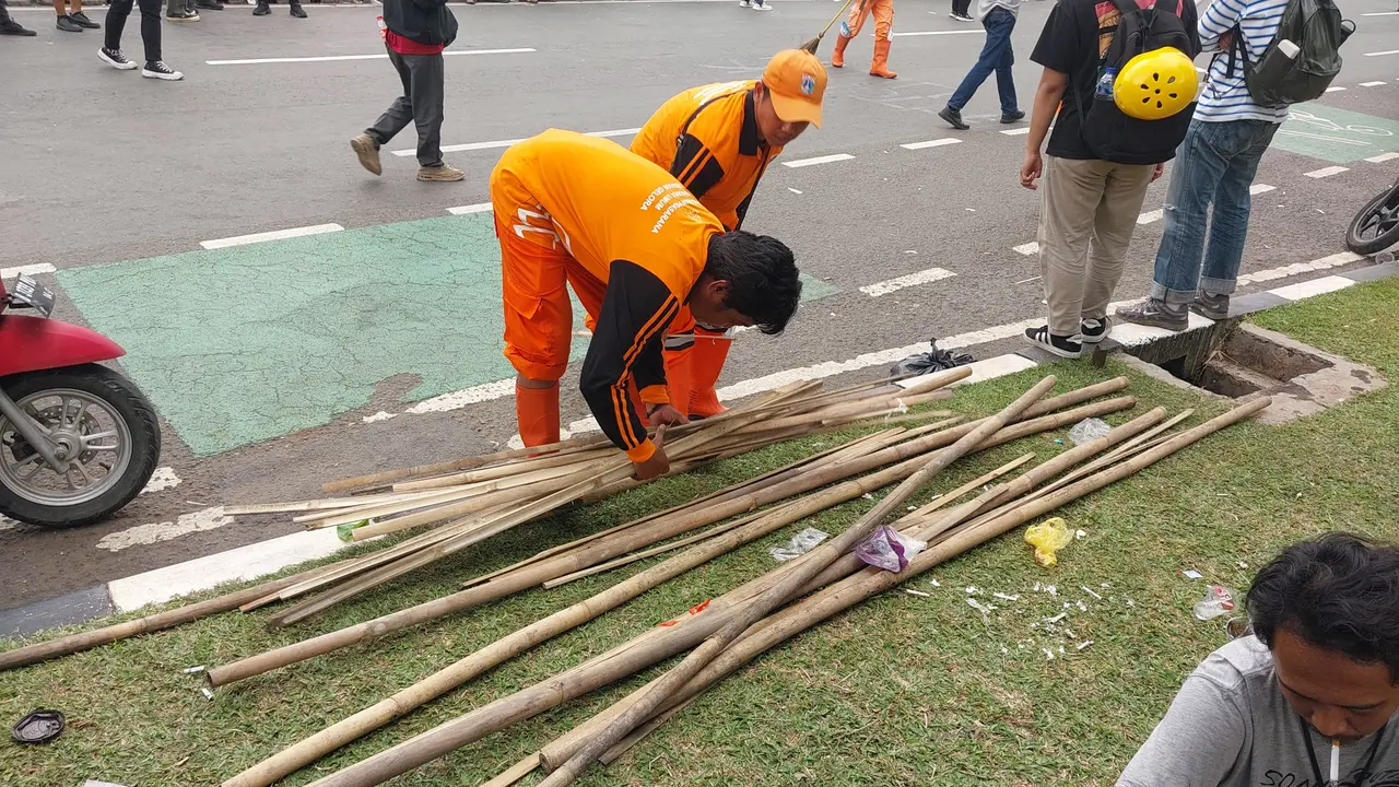 Pasukan orange terlihat di sekitaran Gedung DPR membersihkan bambu sisa-sisa tiang bendera. (Foto: Liputan6.com/Liputan6.com/Arief RH)