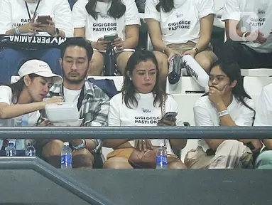 Pasangan artis Syahnaz Sadiqah (topi putih) dan Jeje Govinda (kemeja) duduk bersama menyaksikan pertandingan Lagi-lagi Tenis di Tennis Indoor Senayan, Jakarta Pusat, Jumat (23/6/2023). (Fimela.com/Bambang E Ros)