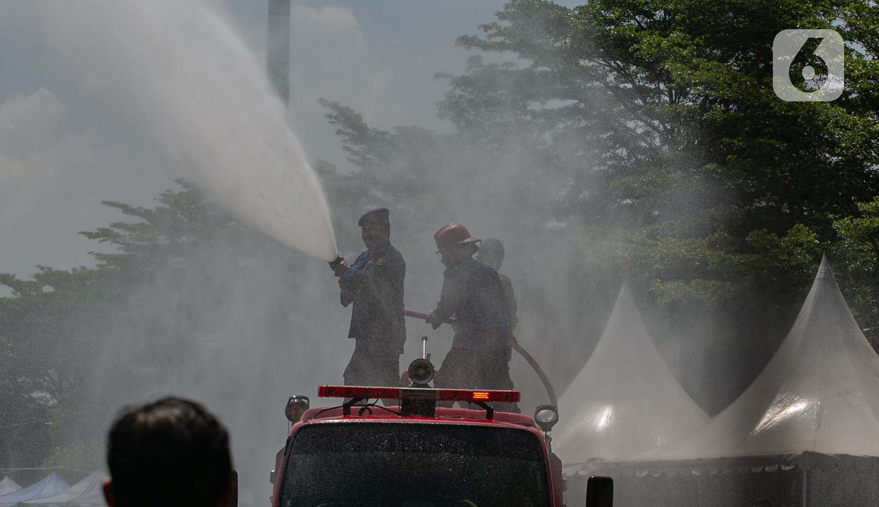 Penyemprotan tersebut dilakukan untuk mendinginkan tenda tenda yang digunakan pemudik motor berteduh sebelum menaiki kapal untuk menyeberang. (Liputan6.com/Angga Yuniar)