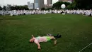 Seorang pria berbaring di rumput dengan latar belakang Diner en blanc di Rockefeller Park, New York, Rabu (17/7/2019). New York City Diner en Blanc adalah sebuah pesta makan malam rahasia dengan pakaian bernuansa putih yang diadopsi dari budaya Prancis. (TIMOTHY A. CLARY / AFP)