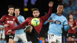 Pemain Valencia Cristiano Piccini (tengah) berebut bola dengan pemain Celta Vigo Renato Tapia (kanan) pada pertandingan Liga Spanyol di Stadion Balaidos, Vigo, Spanyol, 5 Desember 2021. Valencia menang 2-1. (MIGUEL RIOPA/AFP)