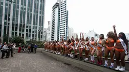 Juru foto mengambil gambar dari belasan wanita seksi yang berpose di Paulista Avenue, Sao Paulo, Senin (8/8). Mengenakan bikini, para wanita tersebut mempromosikan kontes Miss BumBum 2016. (Miguel SCHINCARIOL/AFP)