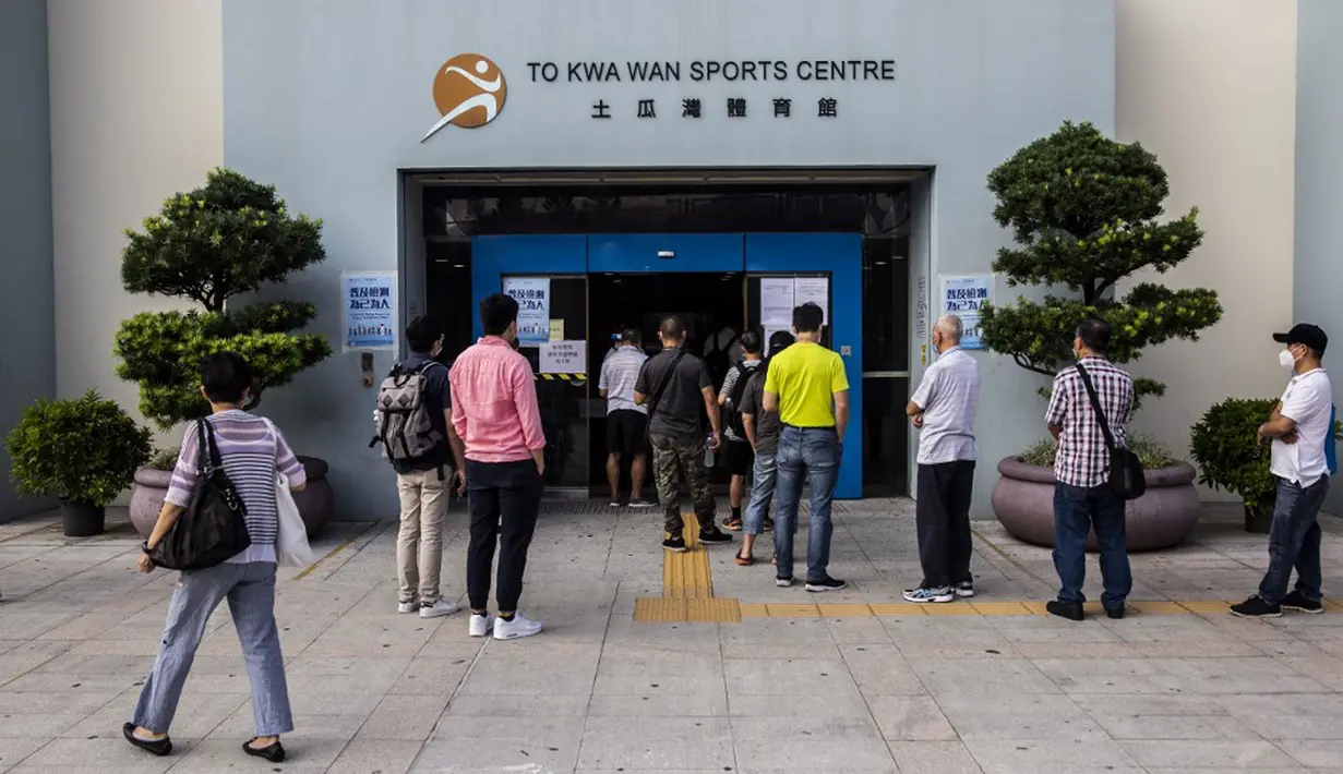 Sejumlah orang menunggu dalam antrean di pusat pengujian virus corona COVID-19, Hong Kong, Selasa (1/9/2020). Hong Kong mulai melakukan tes massal virus corona COVID-19. (ISAAC LAWRENCE/AFP)
