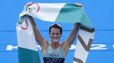 Atlet Bermuda, Flora Duffy berbelebrasi setelah melewati garis finis untuk meraih medali emas dalam triathlon nomor individu putri Olimpiade Tokyo 2020 di Odaiba Marine Park, Selasa (27/7/2021). Flora Duffy menjadi penyumbang medali emas untuk negara berpenduduk 60 ribu orang itu. (AP/David Goldman)