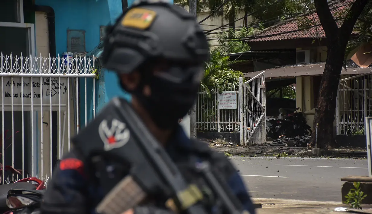 Polisi berjaga di lokasi gereja setelah ledakan di Makassar (28/3/2021).  Ledakan terjadi sekitar pukul 10.28 Wita tepat saat sejumlah jemaah gereja tengah beribadah. (AFP/Indra Abriyanto)