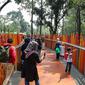 Pengunjung melintasi jembatan di Tebet Eco Park, Jakarta, Selasa (10/5/2022). Warga memanfaatkan libur dengan bermain dan berolahraga di taman terbuka setelah pemerintah memperpanjang masa liburan sekolah hingga tanggal 11 Mei 2022. (Liputan6.com/Faizal Fanani)