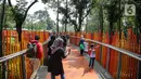 <p>Pengunjung melintasi jembatan di Tebet Eco Park, Jakarta, Selasa (10/5/2022). Warga memanfaatkan libur dengan bermain dan berolahraga di taman terbuka setelah pemerintah memperpanjang masa liburan sekolah hingga tanggal 11 Mei 2022. (Liputan6.com/Faizal Fanani)</p>