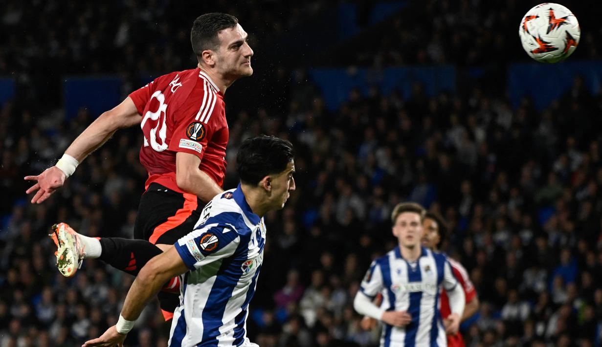 Pemain belakang Manchester United, Diogo Dalot (atas) berebut boal atas dengan Nayef Aguerd (Real Sociedad) saat laga leg pertama 16 besar Liga Europa 2024/2025 di Stadion Anoeta, San Sebastian, Kamis 6 Maret 2025 waktu setempat atau Jumat (7/3/2025) dini hari WIB. (ANDER GILLENEA/AFP)