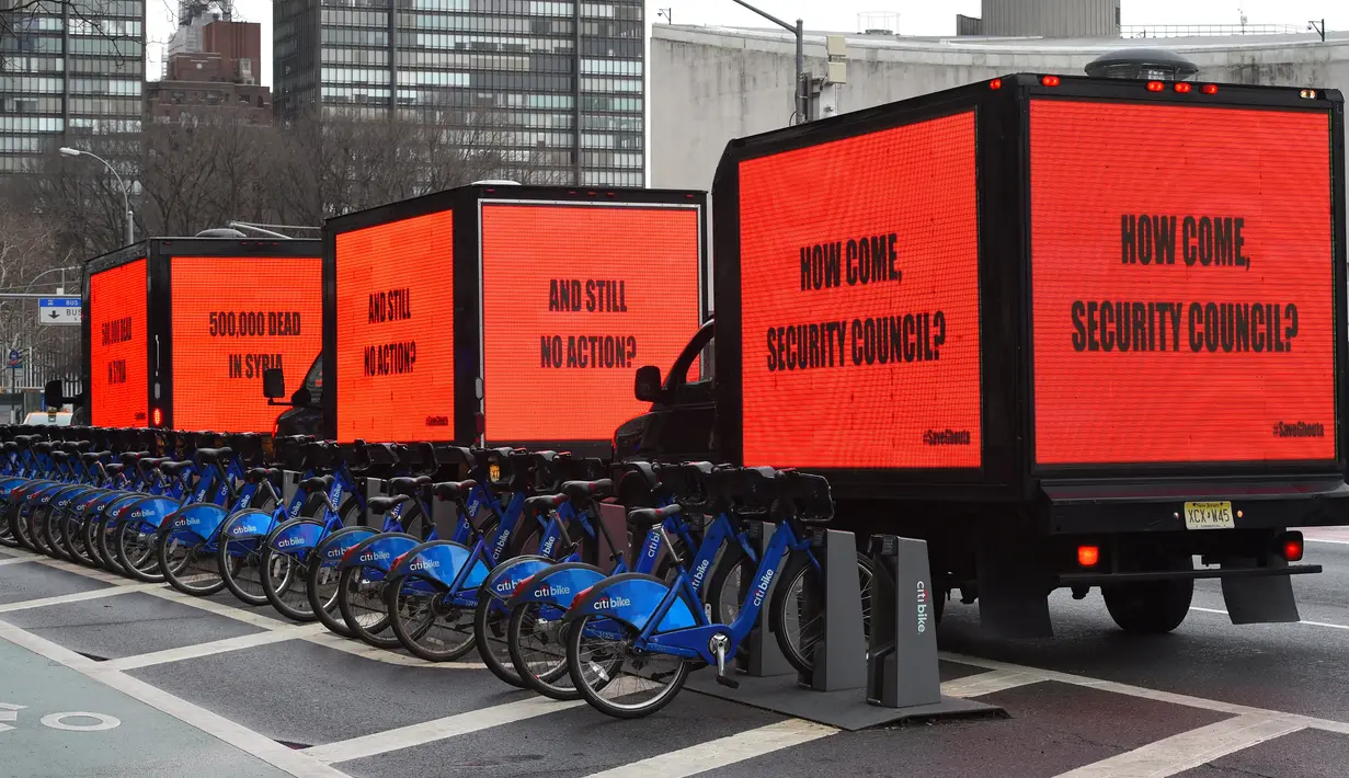 Sejumlah mobil box membawa billboard yang bertema kepedulian untuk Suriah mengelilingi gedung Perserikatan Bangsa-Bangsa (PBB) di New York (22/2). Mereka melakukan kampanye untuk kepedulian terkait perang saudara di Suriah. (AFP Photo/Timothy A. Clary)