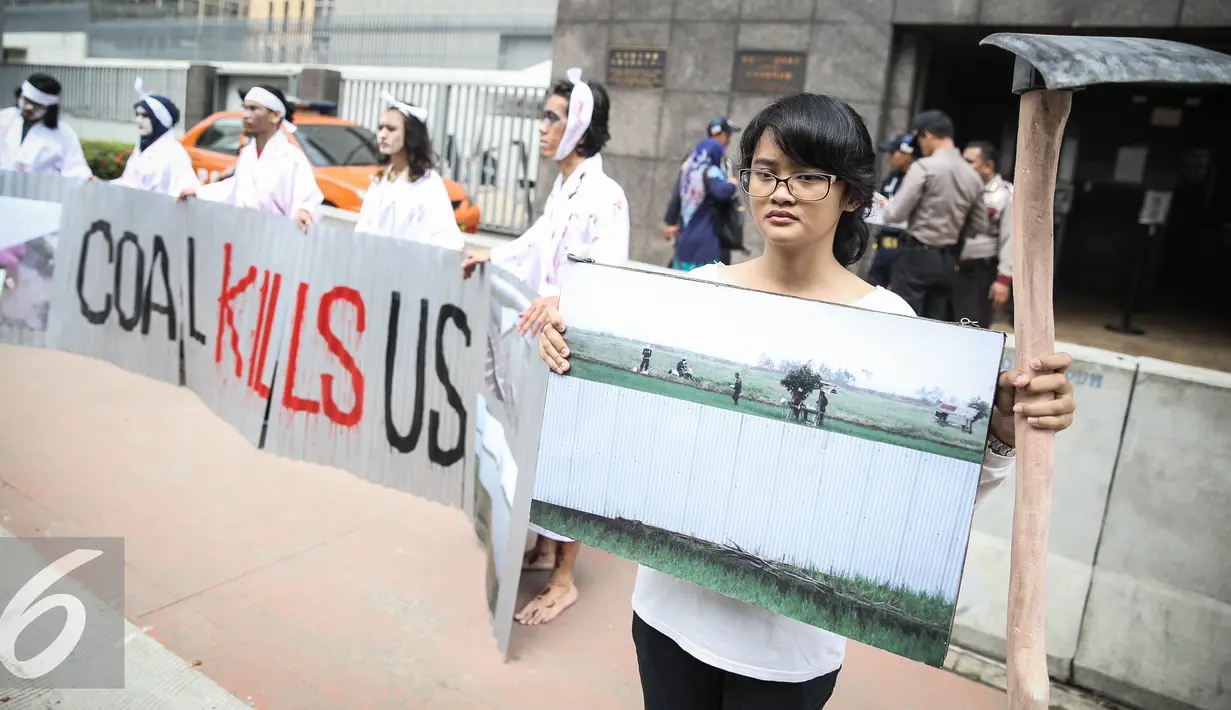 Massa aksi yang tergabung dalam SKWB membawa foto saat menggelar aksi didepan Kedutaan Besar Jepang, Jakarta, Jumat (1/4). Dalam aksinya mereka menolak rencana pembangunan megaproyek PLTU batu bara. (Liputan6.com/Faizal Fanani)