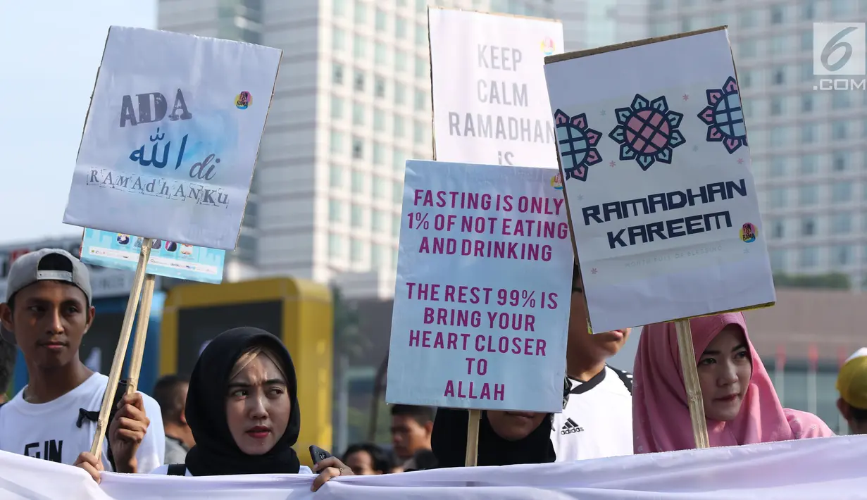Beragam tulisan menyambut datangnya bulan Ramadan dibawa sejumlah remaja saat acara Car Free Day di Bundaran Hotel Indonesia, Jakarta, Minggu (13/5). Mereka mengajak warga untuk menyambut bulan suci bagi umat muslim. (Liputan6.com/Helmi Fithriansyah)