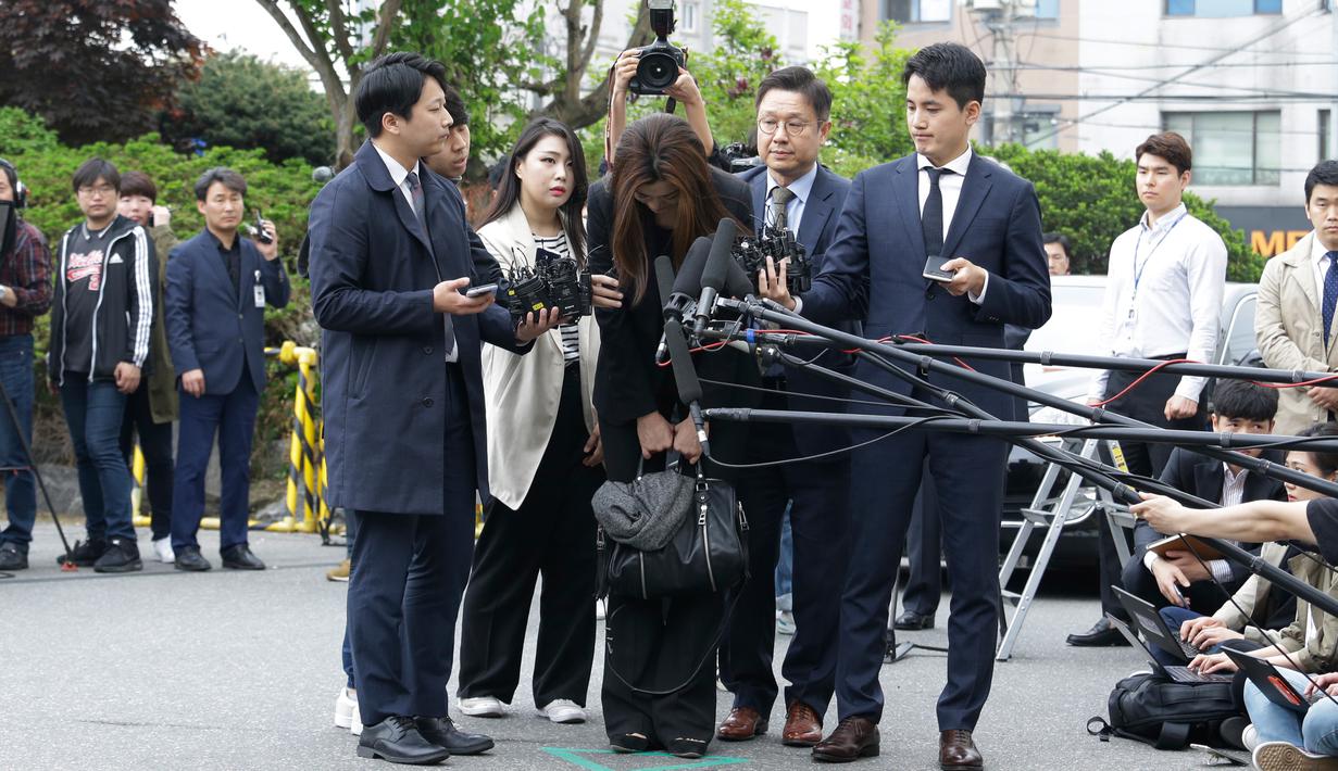 Mantan eksekutif senior Korea Air, Cho Hyun-min dengan kepala tertunduk meminta maaf ketika tiba di kantor polisi Seoul, Selasa (1/5). Cho meminta maaf atas insiden melemparkan minuman di wajah orang pada pertemuan April lalu. (AP/Ahn Young-joon)