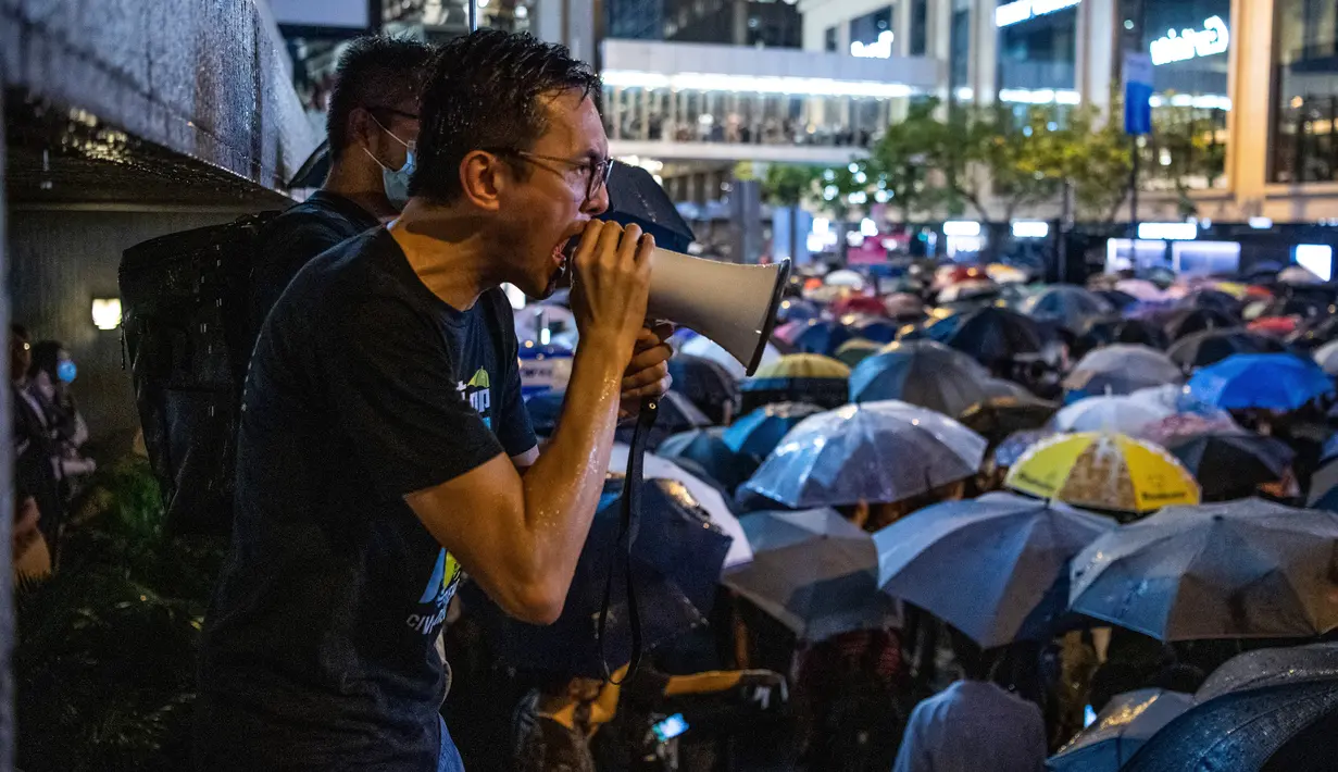 Seorang pria berteriak menggunakan pengeras suara saat ribuan pegawai negeri sipil (PNS) mengikuti unjuk rasa menolak RUU Ekstradisi di Hong Kong, Jumat (2/8/2019). Aksi para pegawai negeri sejatinya telah ditentang oleh pemerintah Hong Kong. (LAUREL CHOR/AFP)