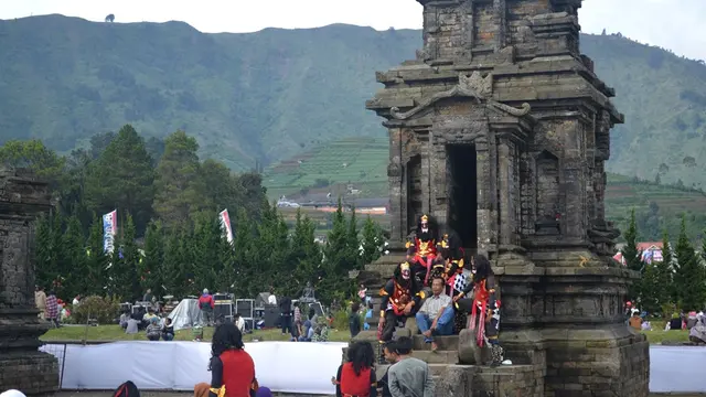 Pengunjung berfoto dengan para penari Rampak Yakso Pringgondani, Dieng di Kompleks Candi Arjuna, Dieng, Jawa Tengah. (Foto: Liputan6.com/Muhamad Ridlo)