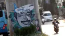 Pengendara melintas di sisi mural bergambar aktivis HAM, Munir di Jalan Ciledug Raya, Jakarta, Senin (7/9/2020). Munir Said Thalib seorang aktivis HAM Indonesia meninggal dunia setelah diracun dalam penerbangan menuju Amsterdam, Belanda pada 7 September 2004. (Liputan6.com/Helmi Fithriansyah)