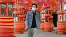 Seorang pria yang mengenakan masker berjalan di sepanjang jalan di Hong Kong, Jumat (28/1/2022). Hong Kong memangkas masa karantina wajib bagi orang-orang yang datang dari luar negeri dari 21 menjadi 14 hari. (AP Photo/Kin Cheung)