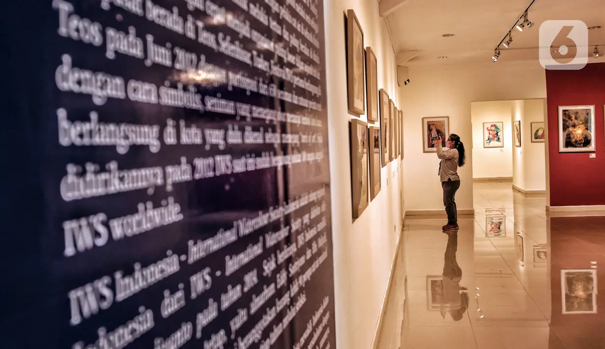 Seorang pengunjung mengambil gambar karya yang ditampilkan dalam pameran International Watercolor 2022 "Wonderful Indonesia" di Gedung B Galeri Nasional Indonesia, Jakarta Pusat, Kamis (24/11/2022). Pameran ini bertujuan untuk memperkenalkan pesona Indonesia lewat karakter berbeda dan upaya untuk memasyarakatkan seni lukis cat air kepada khalayak. (merdeka.com/Iqbal S. Nugroho)