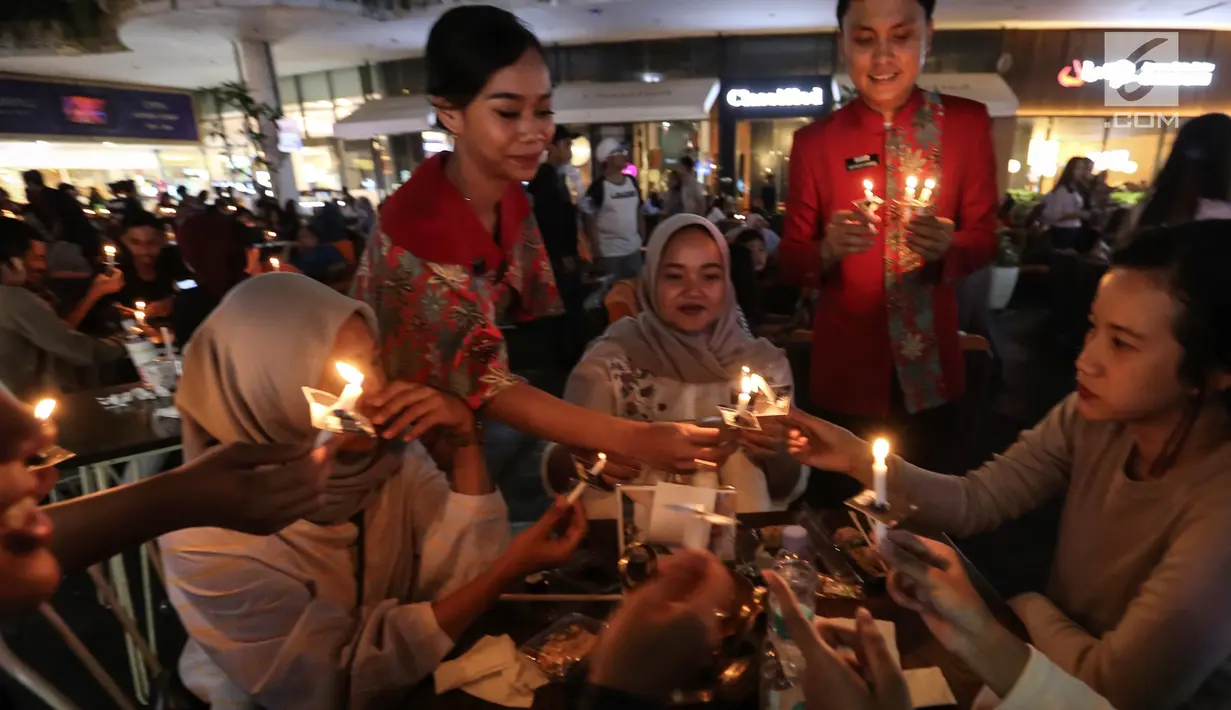 Pengunjung menyalakan lilin untuk mendukung Earth Hour 2019 di Lippo Mall Kemang, Jakarta, Sabtu (30/3). Sebanyak 300 lilin dibagikan kepada pengunjung guna menghemat daya listrik sekitar 0,5% dari energi yang terpakai selama 60 menit. (Liputan6.com/Fery Pradolo)