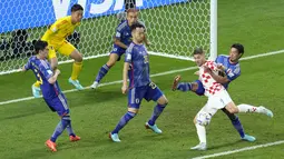 Pemain Kroasia,&nbsp;Andrej Kramaric (kanan) berusaha mencetak gol ke gawang Jepang saat laga 16 besar Piala Dunia 2022 yang berlangsung di Al Janoub Stadium, Senin (05/12/2022). (AP/Ricardo Mazalan)