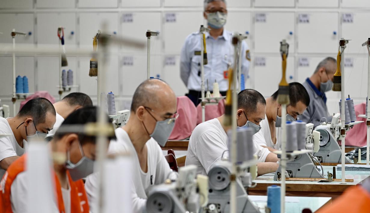 Para tahanan menggunakan mesin jahit saat membuat masker di Penjara Taipei di Kota Taoyuan, Taiwan utara (10/3/2020). Taiwan berhasil mempertahankan jumlah kasus virus corona yang dikonfirmasi menjadi 45 dan satu kematian. (AFP/Sam Yeh)