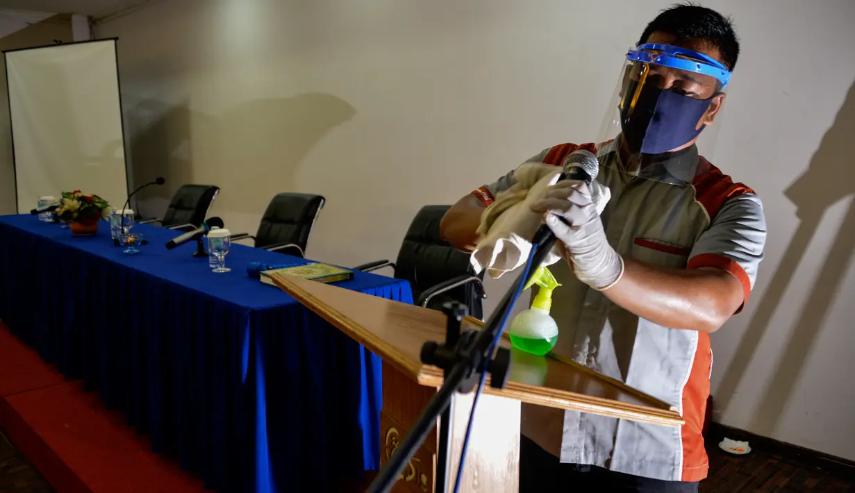 Seorang pekerja dengan mengenakan alat pelindung membersihkan ruang pertemuan di sebuah hotel yang dibuka kembali setelah ditutup selama tiga bulan akibat pandemi COVID-19 di Banda Aceh pada Rabu (15/7/2020). (Photo by CHAIDEER MAHYUDDIN / AFP)