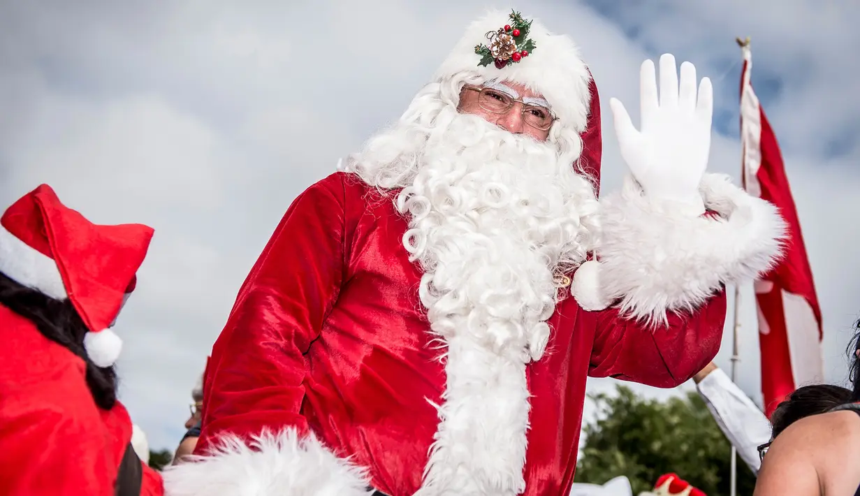 Santa Claus melambaikan tangan setibanya Kongres Dunia Sinterklas di Kopenhagen, Denmark, Senin (23/7). Kegiatan itu merupakan sarana dimana seluruh santa di dunia bisa bertemu dan melakukan aktivitas bersama. (Mads Claus Rasmussen/Scanpix via AP)