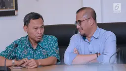 Komisioner KPU RI, Pramono Ubaid Tanthowi (kiri) berbincang dengan Ilham Saputra disela-sela penyampaian keterangan terkait putusan PTUN yang memenangkan gugatan PKPI di gedung KPU, Jakarta, Kamis (12/4). (Liputan6.com/Helmi Fithriansyah)