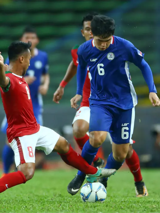 Pemain Timnas Indonesia U-22, Muhammad Hargianto berusaha merebut bola pemain Filipina Yoshiharu Koizumi pada laga SEA Games di Stadion Shah Alam, Selangor (17/8). Indonesia menang 3-0 atas Filipina. (AP Photo / Vincent Phoon)
