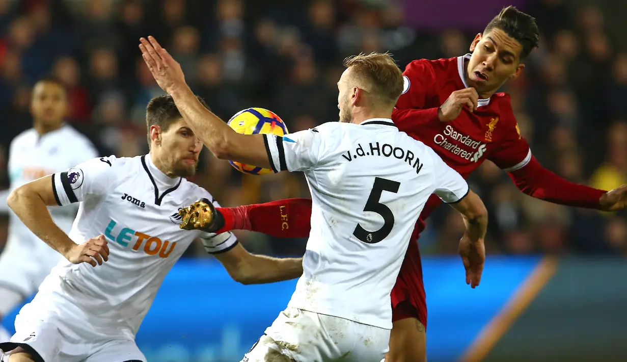 Pemain Liverpool, Roberto Firmino berebut bola dengan bek Swansea City, Mike van der Hoorn dalam lanjutan Premier League di Stadion Liberty, Selasa (23/1). Liverpool tumbang 0-1 dari penghuni dasar klasemen Liga Inggris Swansea. (Geoff CADDICK/AFP)