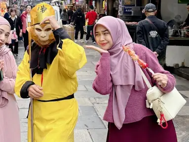 Jalan-jalan di muslim street, Ria Ricis dan Nadzira Shafa terlihat sangat kompak. Keduanya tampil cantik dengan warna hijab yang senada. Ricis dan Nadzira berfoto dengan orang berkostum Sun Go Kong, karakter kera sakti dalam serial populer 'Journey to the West'. (Liputan6.com/IG/@riaricis1795)