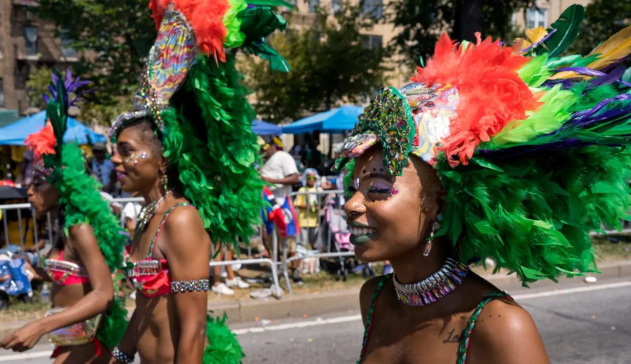 Sejumlah penari wanita mengenakan hiasan kepala saat mengikuti parade West Indian Day di Brooklyn, New York, Senin (3/9). Komunitas Karibia di New York telah mengadakan perayaan tahunan Karnaval sejak tahun 1920. (AP Photo/Craig Ruttle)