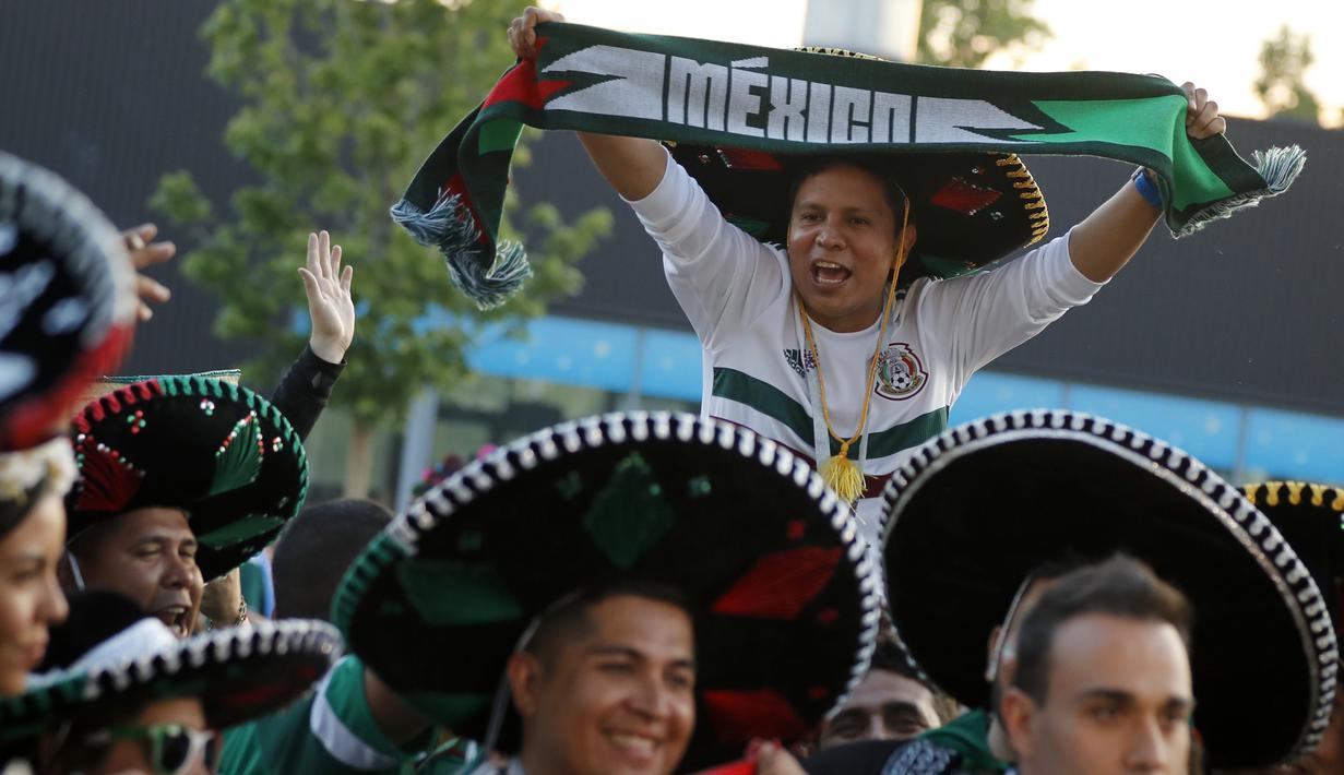 Suporter Meksiko menggunakan topi tradisional, Sombrero saat merayakan kemenangan timnya atas Jerman pada Piala Dunia 2018 di Luzhniki Stadium, Moskow, (17/6/2018). Meksiko menan 1-0. (AP/Alexander Zemlianichenko)