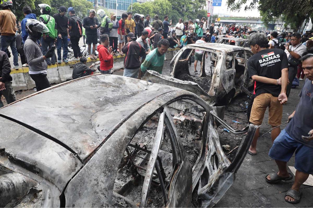 FOTO: Warga Ambil Bangkai Mobil Usai 10 Kendaraan Dibakar di Depan Mako Brimob Kwitang