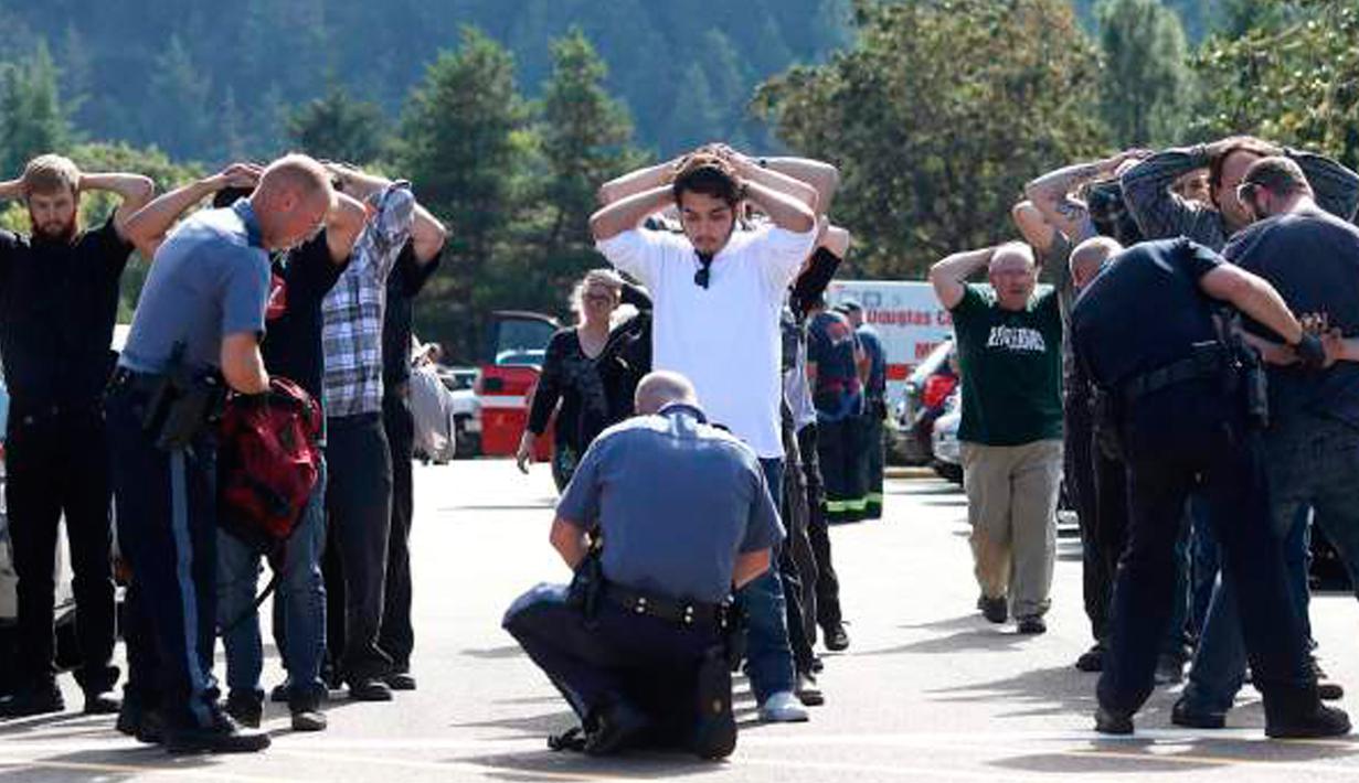 Polisi memeriksa tas mahasiswa dan staf setelah terjadi penembakan di Umpqua Community College di Roseburg, Oregon, AS, Kamis (1/10/2015). 13 orang tewas dan sekitar 20 lainnya terluka akibat kejadian tersebut. (REUTERS/Michael Sullivan/The News-Review)