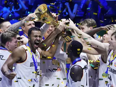 Pemain Timnas Basket Jerman melakukan selebrasi dengan mengangkat Piala Dunia FIBA 2023 setelah mengalahkan Serbia dalam pertandingan final yang berlangsung di Mall of Asia Arena, Pasay, Filipina, Minggu (10/9/2023) malam WIB. Ini menjadi gelar pertama buat Jerman sejak mengikuti Piala Dunia FIBA sejak 1986. (AP Photo/Michael Conroy)