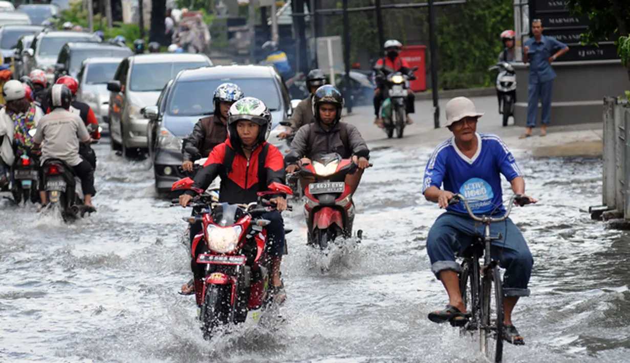 Sejumlah pengendara mencoba melintasi genangan air di jalan Kemang Raya, Jakarta pada Selasa (10/2/2015). (Liputan6.com/Helmi Fithriansyah)