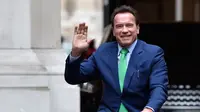 Gubernur California ke-38, Arnold Schwarzenegger tersenyum saat mengendarai sepeda untuk bertemu Walikota Paris, Anne HIdalgo di Paris (11/12). Schwarzenegger berada di Paris untuk menghadiri pertemuan puncak iklim One Planet.  (AFP Photo / Alain Jocard)