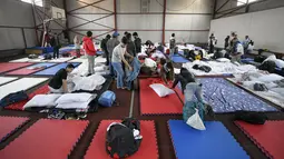 Pelajar yang melarikan diri dari konflik dari negara tetangga Ukraina duduk di sebuah kamp pengungsi di Voluntari, Rumania, Selasa, 1 Maret 2022. PBB menyampaikan informasi bahwa jumlah pengungsi dari Ukraina akibat invasi Rusia telah melebihi setengah juta orang. (AP Photo/Andreea Alexandru)