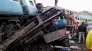 Warga melihat gerbong kereta api yang tergelincir di Andhra Pradesh, India, Minggu (22/1). Sebanyak tujuh gerbong penumpang dan mesin kereta tersebut keluar jalur di dekat Stasiun Kuneru di distrik Vizianagaram. (AP Photo)