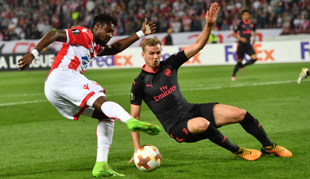 Pemain Belgrade, Richmond Boakye (kiri) mengontrol bola dari adangan pemain Arsenal, Rob Holding (kanan) pada laga grup H Liga europa di Stadion Rajko Mitic, (19/10/2017). Arsenal menang 1-0. (AFP/Andrej Isakovic)